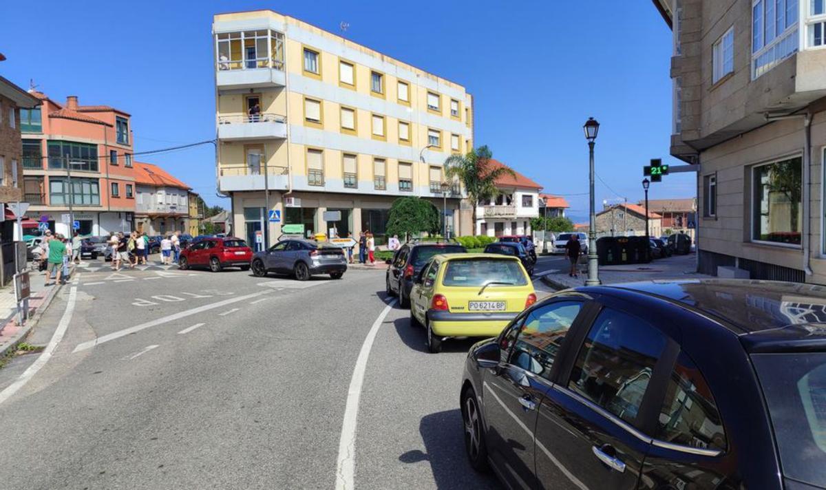 Arriba, vecinos muestran varias pancartas reclamando un acceso para las ambulancias y el estado del cruceiro. A la dcha., retenciones durante la protesta de ayer. |   // S.Á.