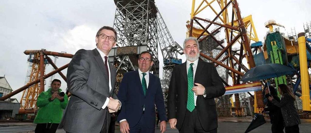 Por la izquierda, Alberto Núñez Feijóo, Orlando Alonso y Esteban García Vilasánchez, ayer, en el astillero de Fene. Al fondo, las primeras cimentaciones para el parque eólico marino East Anglia One.