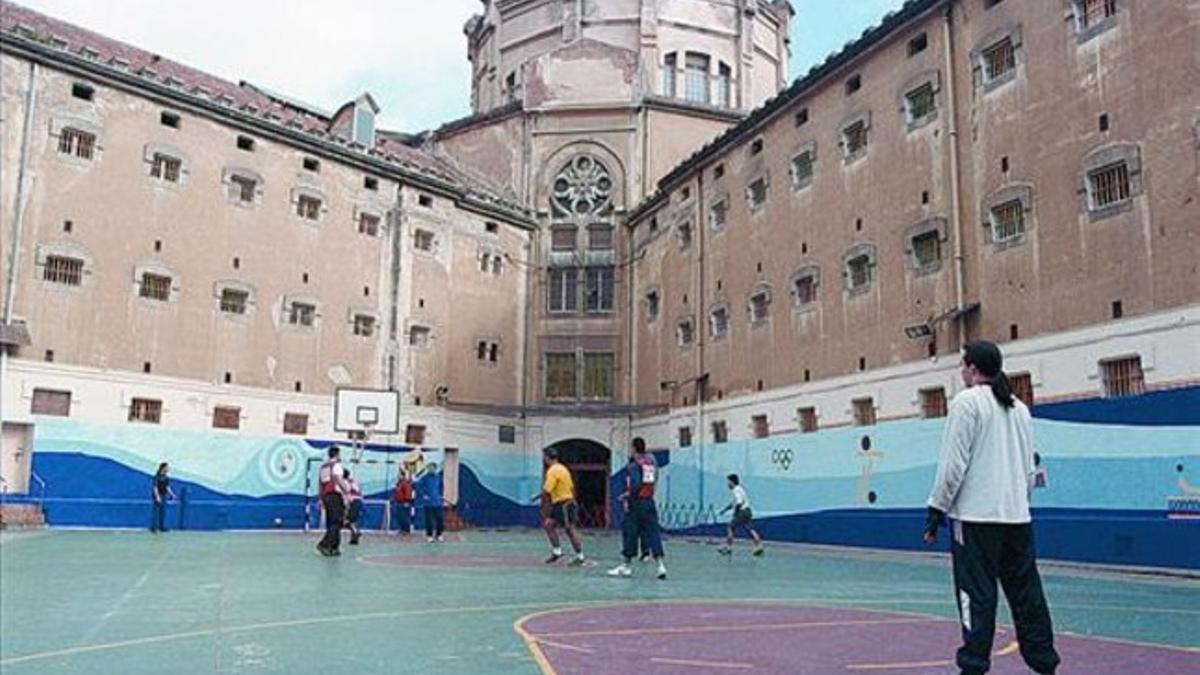 Unos reclusos practican deporte en el patrio de la prisión Modelo de Barcelona.