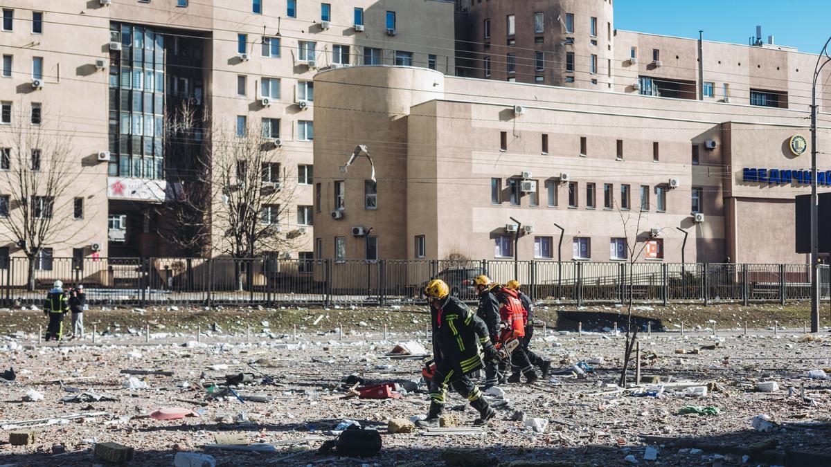 Bomberos y servicios de emergencia en las inmediaciones del edificio civil bombardeado, en una zona residencial, a 26 de febrero de 2022, en Kiev (Ucrania).