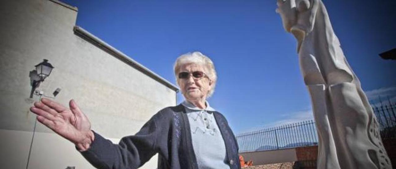 Francisca Cortés Richart fotografiada junto al monumento que la representa a ella con unos niños en brazos.