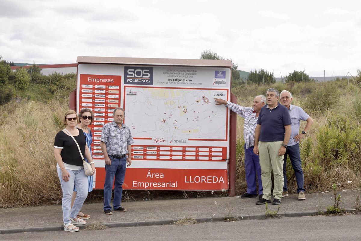 Vecinos delante de un cartel identificativo del polígono de Lloreda.