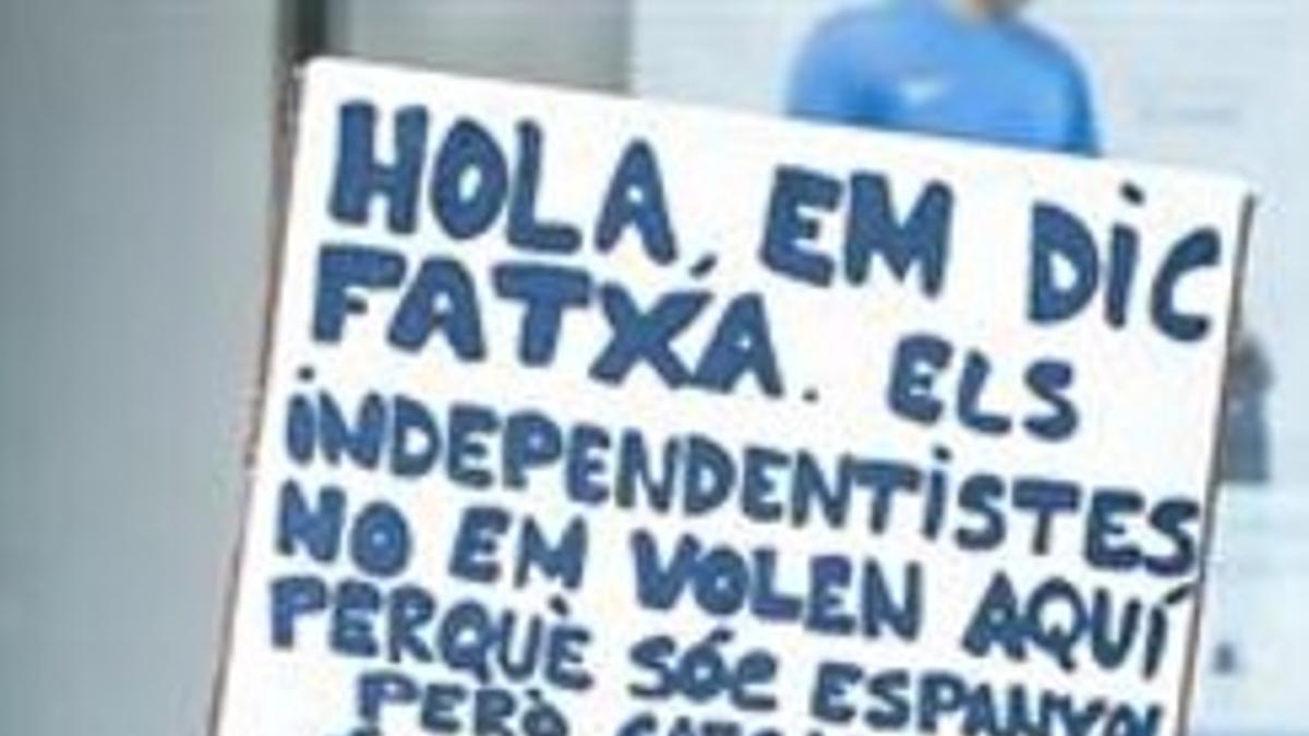 Un asistente al acto de la plaza de Catalunya exhibe un cartel.