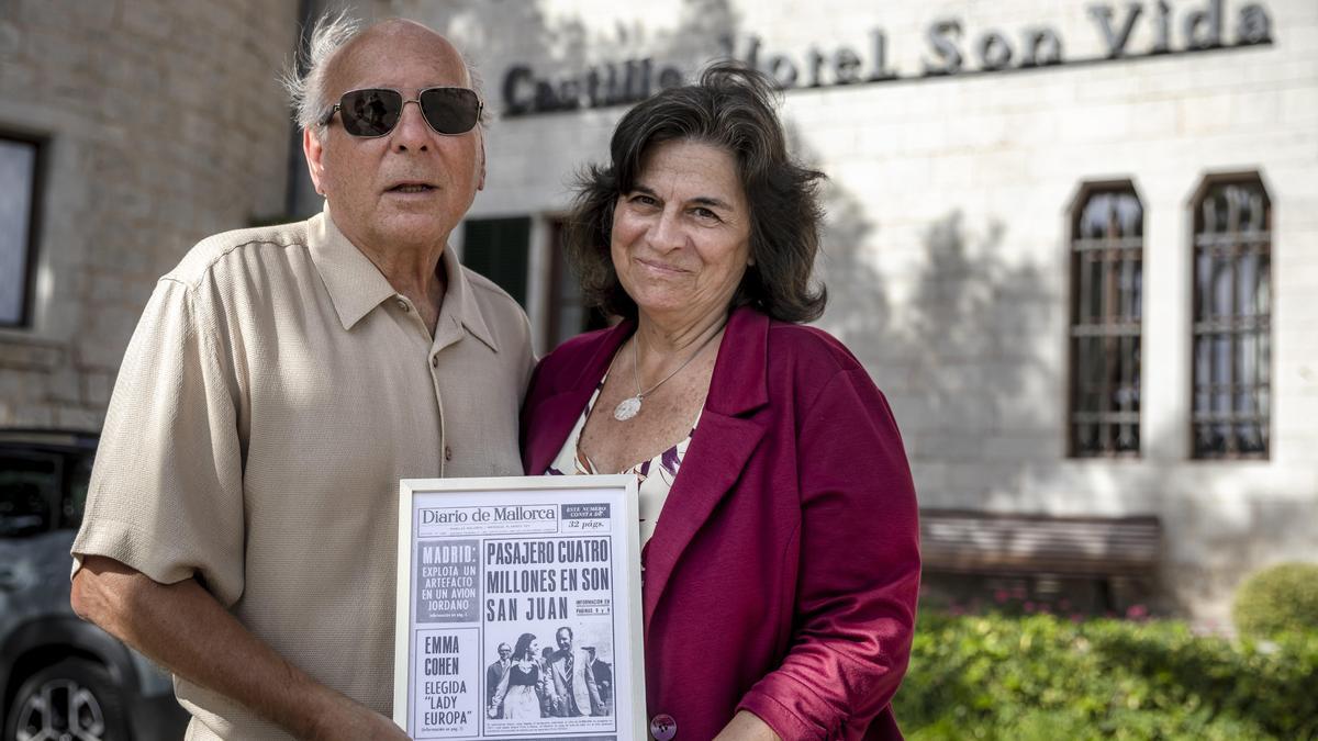 Gary y Lillian Basso posan frente al Castillo Son Vida con la portada enmarcada de este diario, obsequio del hotel.
