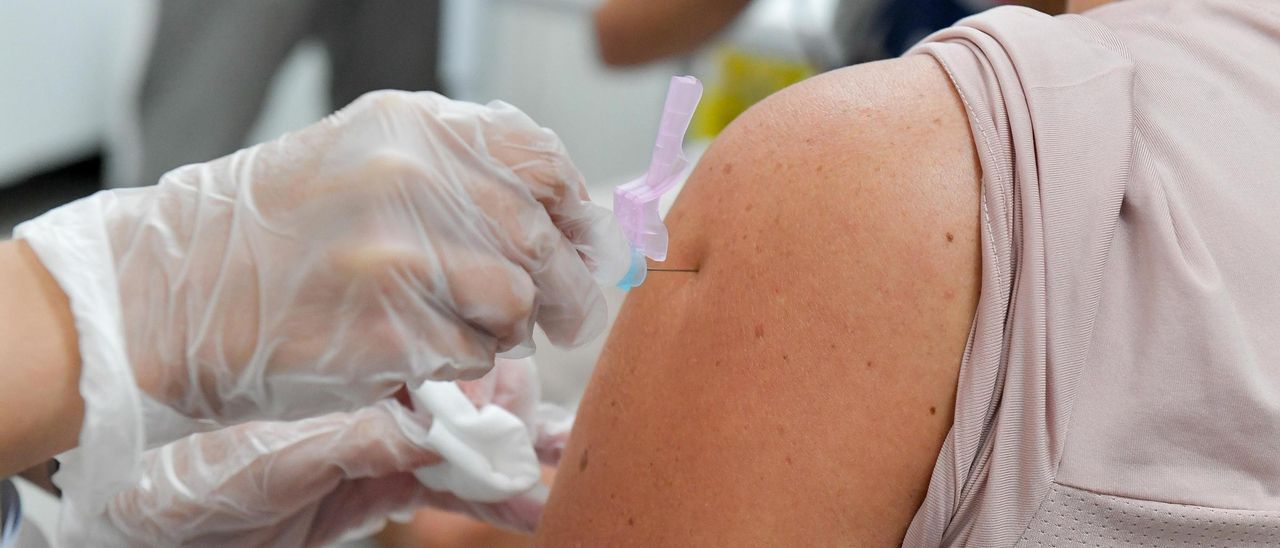 Una mujer recibe la vacuna contra la gripe.