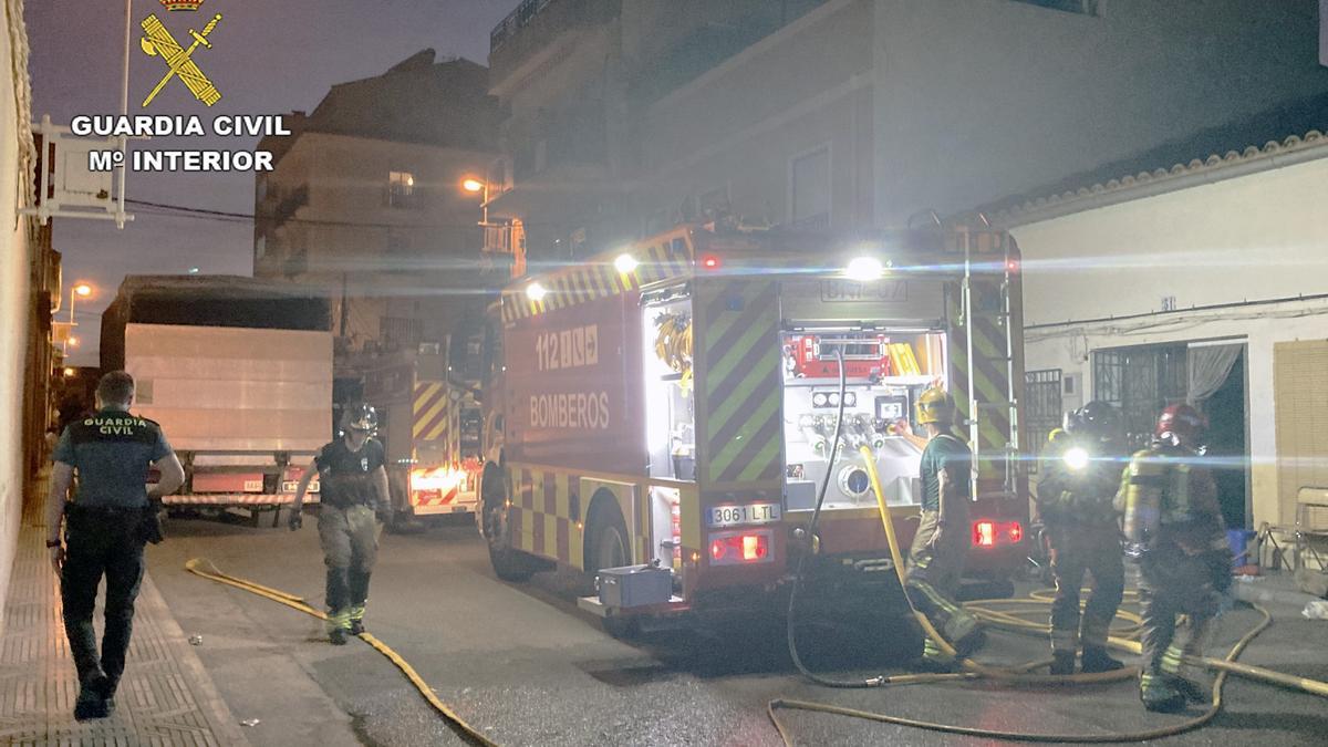 Varios efectivos de bomberos, frente a la vivienda incendiada en Jumilla.