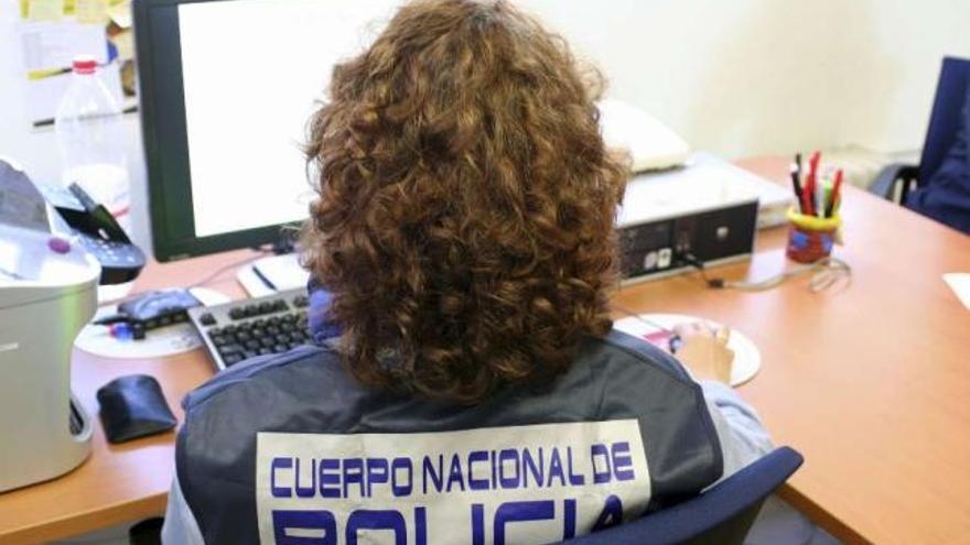 Una policía nacional especializada en delitos tecnológicos, durante una investigación.  // Efe