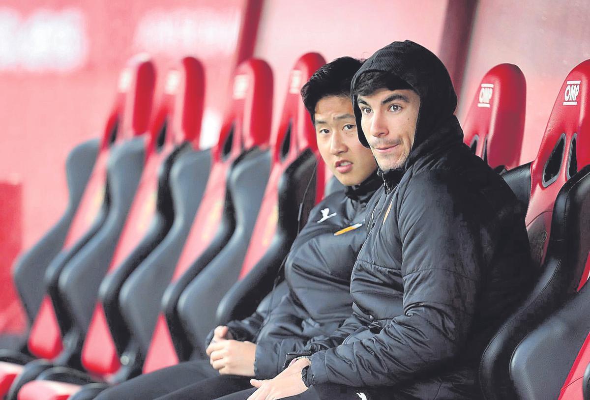 Carlos Soler y Kangin Lee, durante su etapa en el Valencia CF, sentados en un banquillo horas antes de un partido.
