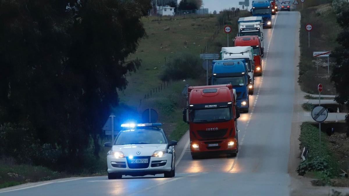 Un coche de la Guardia Civil encabeza uno de los convoyes con materias primas para Covap.