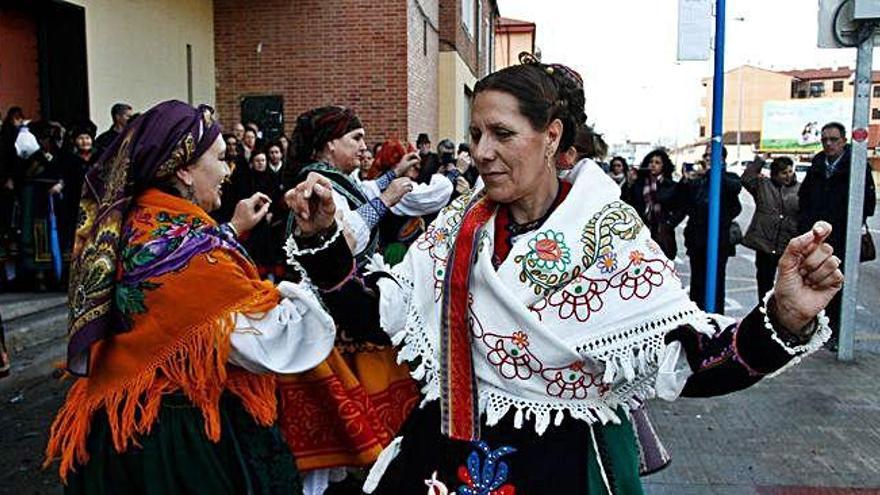 Las mujeres bailan a las puertas de la parroquia de San José Obrero.