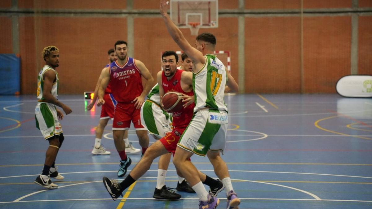 Ángel López (Maristas) intenta una canasta frente a Valeriu Cazacu (Coto).