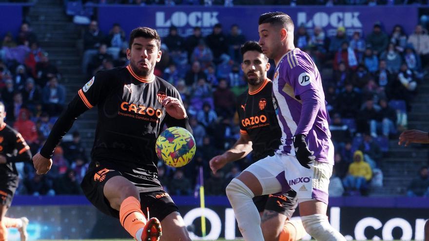  El defensa del Valencia Cenk Ozkacar (i) golpea el balón ante el delantero del Valladolid Sergio León. 