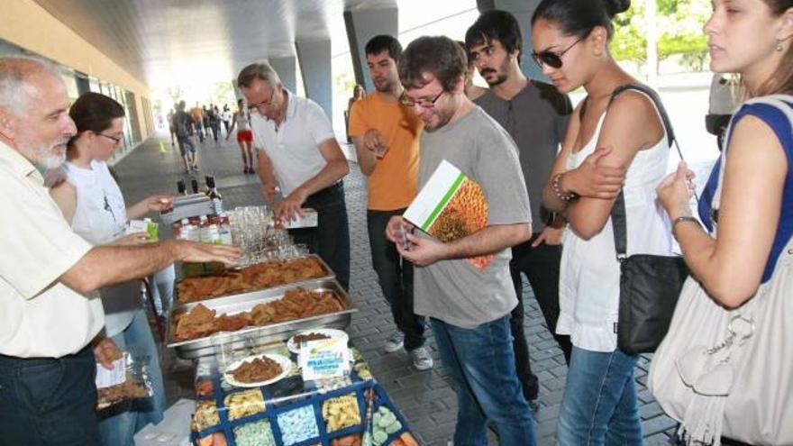 Un grupo de alumnos se acerca a una de las mesas para conocer los beneficios de diversos alimentos.