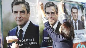 Seguidores de François Fillon pegan carteles de campaña con su imagen en Bayona, el 19 de abril.