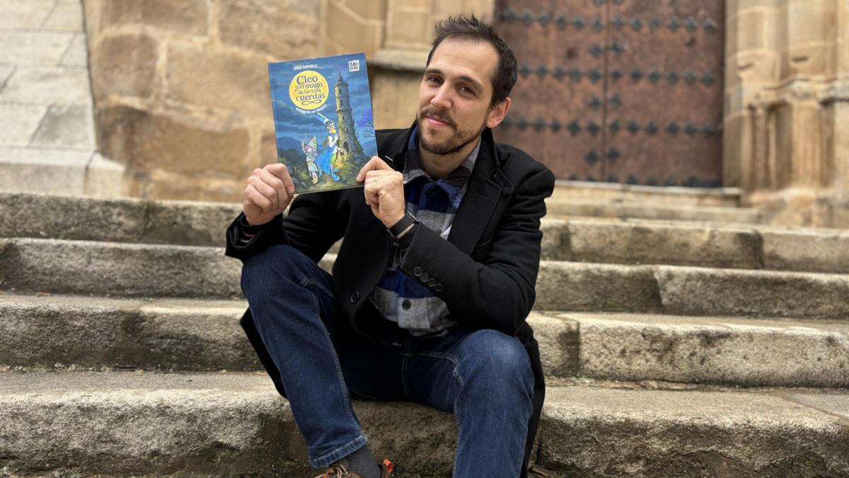 Sergio Barquilla posa con su cuento "Cleo y el mago de las tres cuerdas".