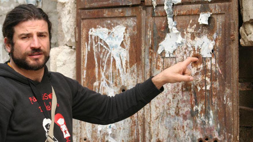 El clown Iván Prado muestra un impacto de bala en la puerta de una vivienda palestina.