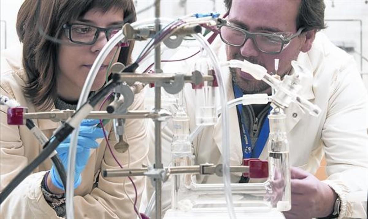 Investigadores 8Marta Blasco y Álvaro Reyes, ante el prototipo del catalizador de hidrógeno.