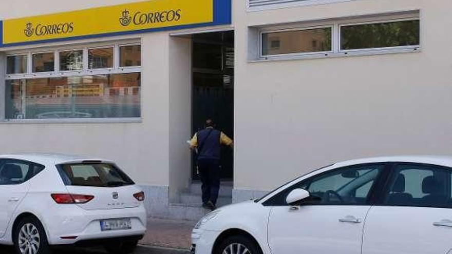 Un trabajador entra a la oficina de Correos de Las Viñas.