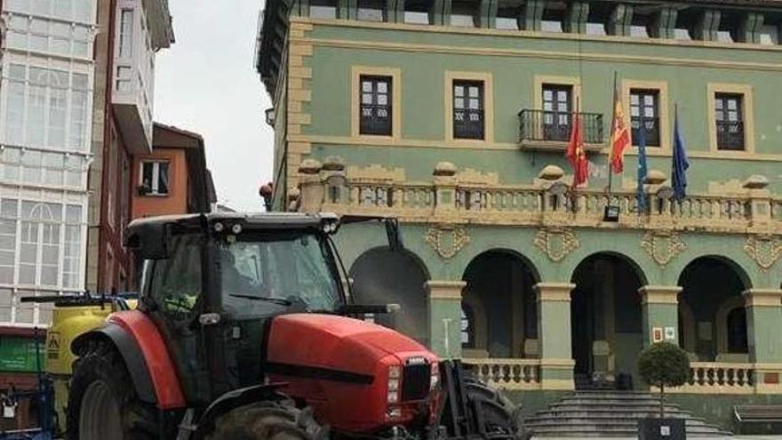 Un tractor pasa junto al Ayuntamiento de Tineo.