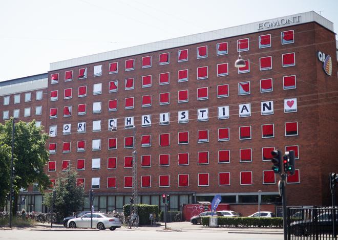 Estudiantes exhiben la bandera danesa y un mensaje de apoyo a Christian Eriksen en su edificio (Copenhague, Dinamarca)
