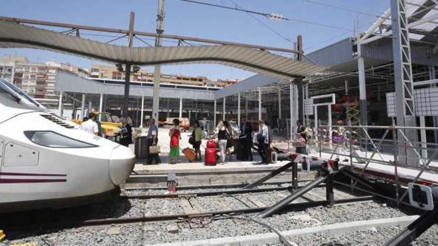 Un grupo de pasajeros se dispone a subir en un tren del modelo &quot;Alvia&quot; que cubre la ruta entre Alicante y Madrid. A partir del día 18 circulará el AVE.