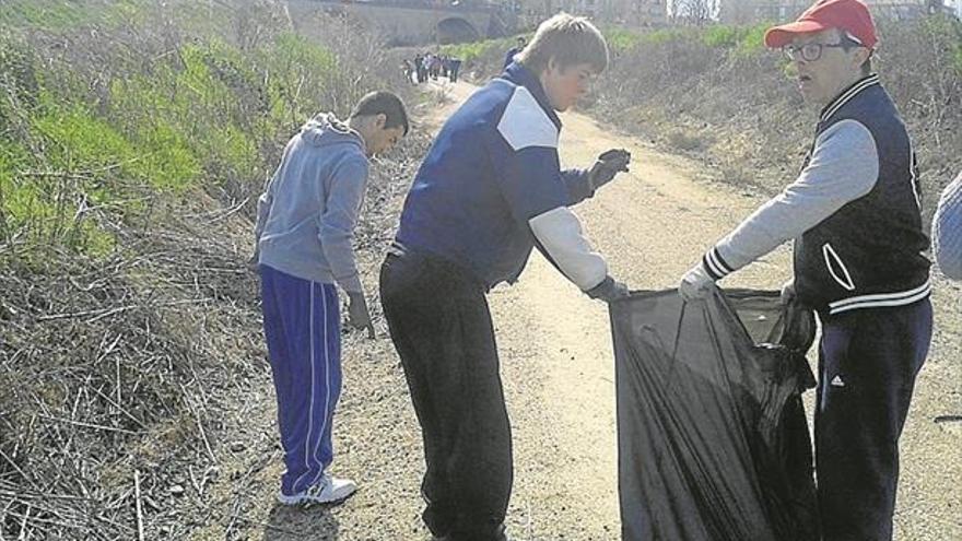 Voluntarios de Inclusives hacen trabajos de limpieza en un tramo de la Vía Verde