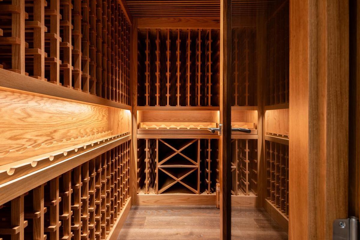 La cava, realizada en maderas nobles y acondicionada para mantener unas condiciones estables de temperatura y humedad, puede almacenar varios cientos de botellas de vino.