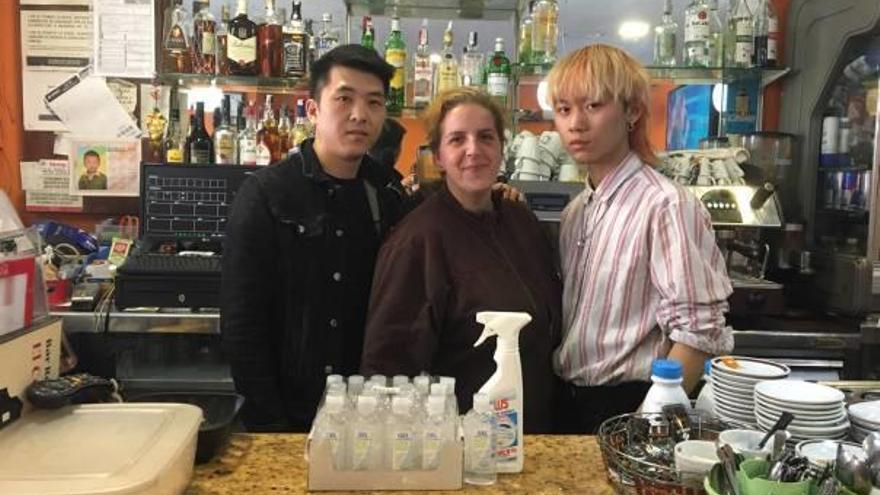 Wei Jing (izquierda), junto a dos empleados, muestran los geles desinfectantes comprados.