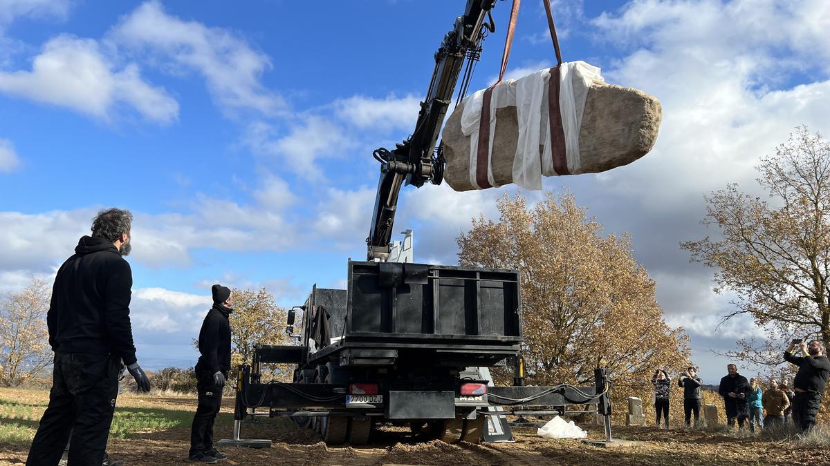 Una grua de grans dimensions descarrega l'estàtua-menhir del Roc de la Mare de Déu (Riner).