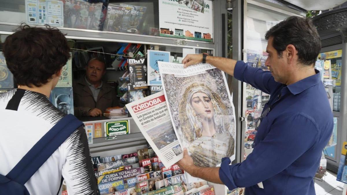 En la imagen, Vicente Mengual, el capataz de los dos pasos que se procesionan este sábado, el del Cristo y el de la Virgen de La Paz y Esperanza, despliega el póster conmemorativo que entrega hoy Diario CÓRDOBA, tras adquirir el periódico.