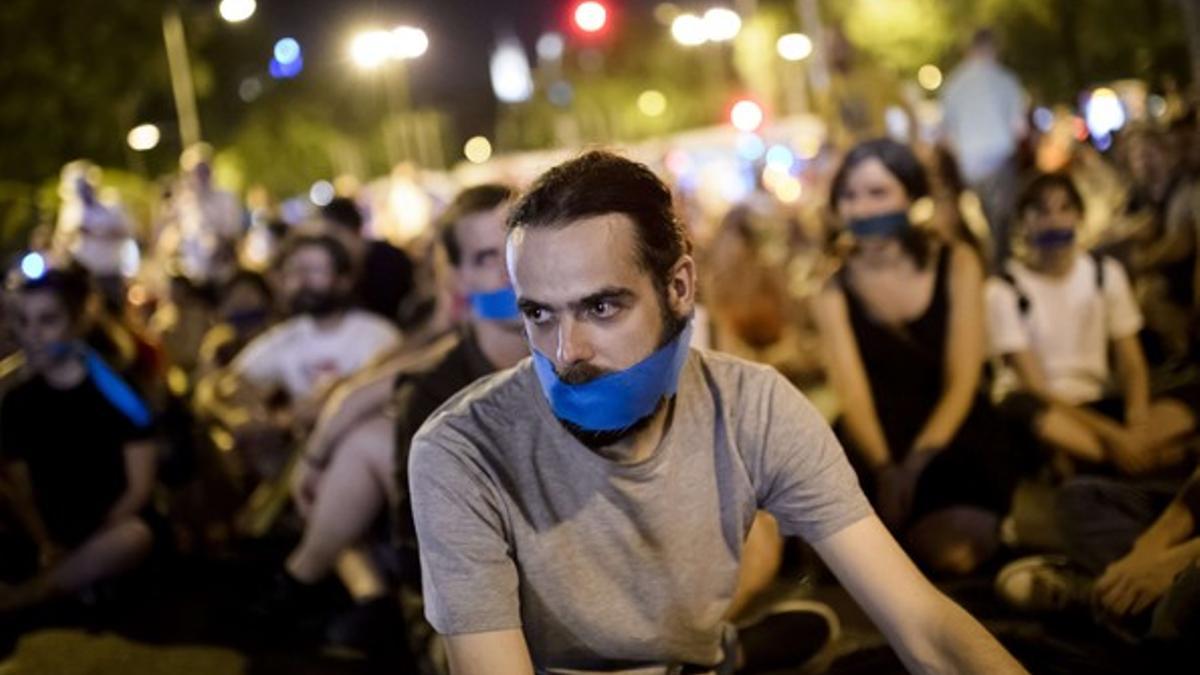 Manifestantes ante el Congreso, anoche, con un pañuelo en la boca para protestar contra la 'ley mordaza'.