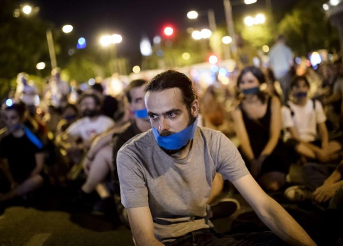 Manifestants davant el Congrés, ahir a la nit, amb un mocador a la boca per protestar contra la ’llei mordassa’.