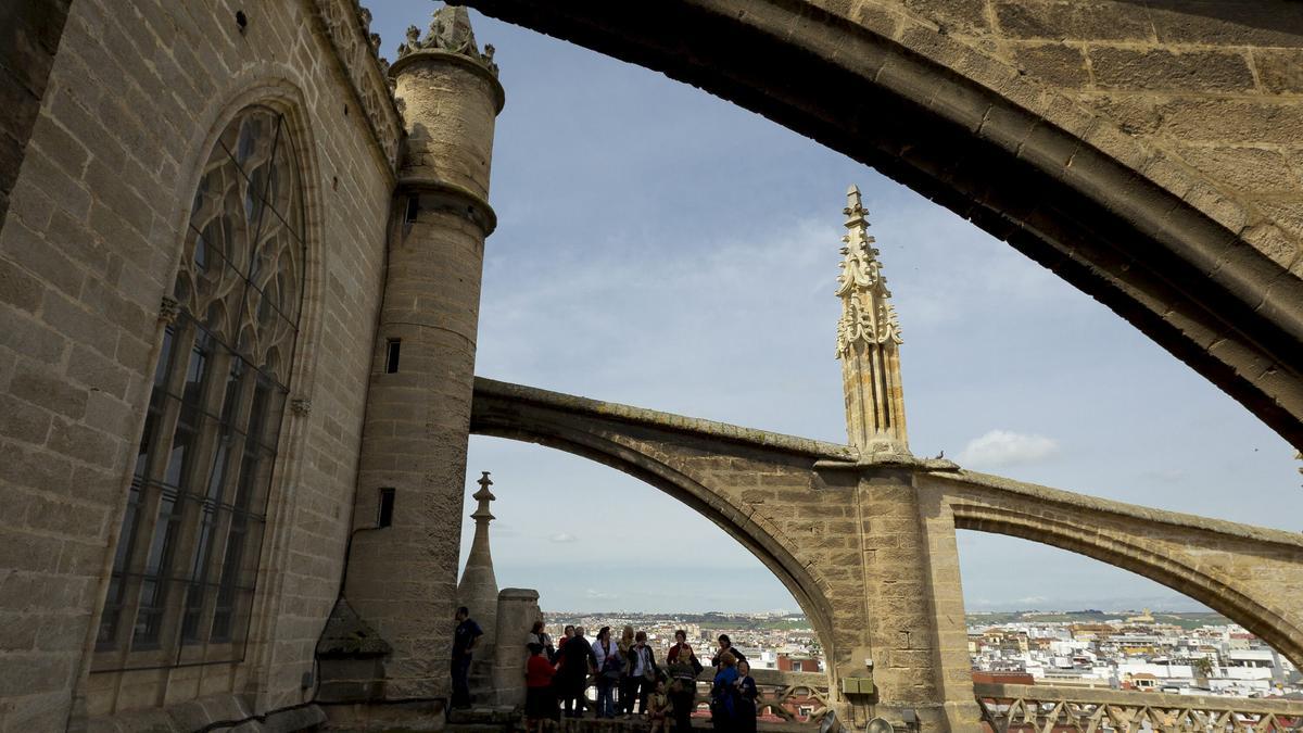 Un grupo de visitantes caminan por la cubierta de las bóvedas de la Catedral de Sevilla, que se puede visitar desde las azoteas para admirar las distintas zonas que componen el mayor templo gótico del mundo desde más de treinta metros de altura.