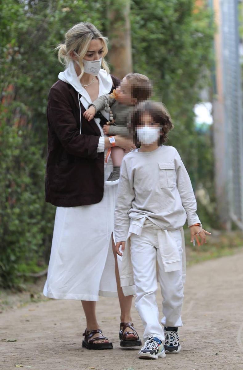 Marta Ortega con vestido blanco y blazer marrón junto a sus hijos