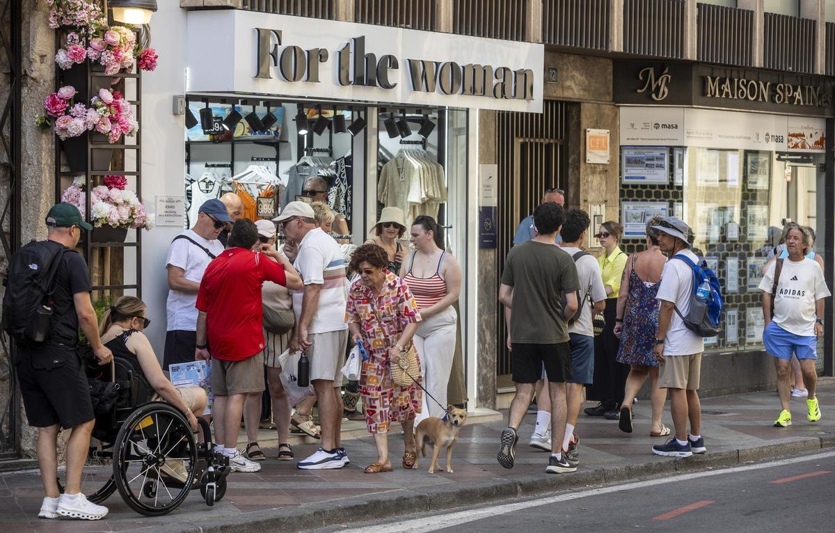 Tienda de ropa con un grupo de cruceristas a su puerta, en la calle Altamira .