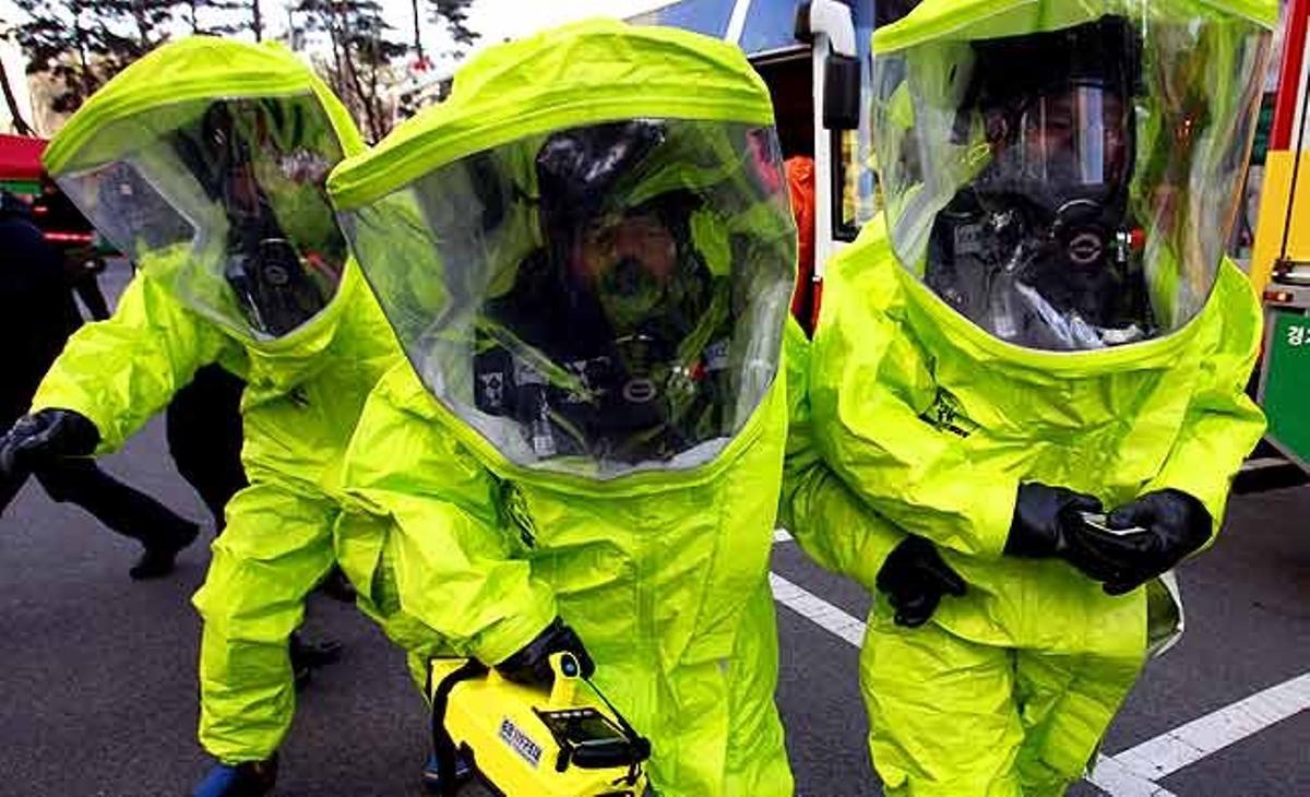Membres de l’equip de materials perillosos, amb màscares de gas i vestits de protecció contra productes químics, participen en un simulacre de defensa civil contra un possible atac de Corea del Nord a prop de la ciutat fronterera de Paju (Corea del Sud).