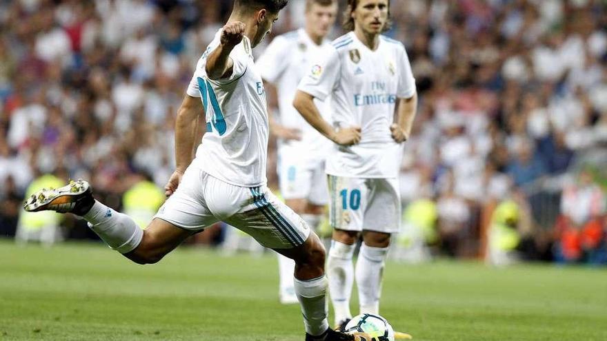 Marco Asensio lanza la falta con la que anotó su segundo gol, con Modric y Kroos siguiendo el golpeo de su joven compañero. // Javier López