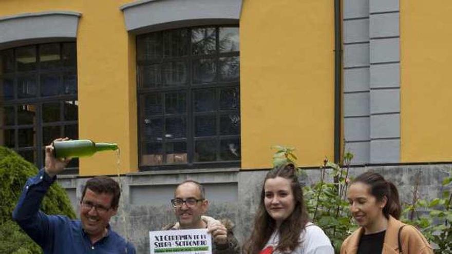 Juanjo García escancia un culete junto a Rafa de la Torre, Esther González y María Alonso ante el Ayuntamiento de San Martín.