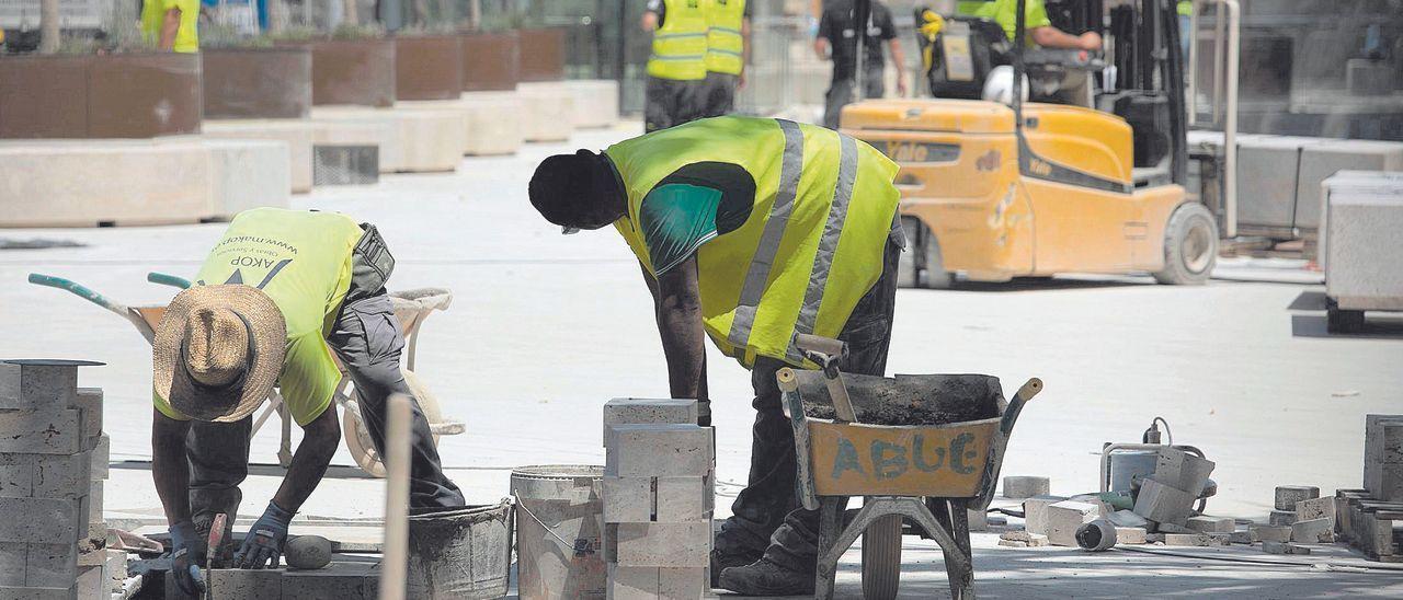 Dos trabajadores realizan tareas físicas durante la mañana en una de las obras del centro de la ciudad de València.