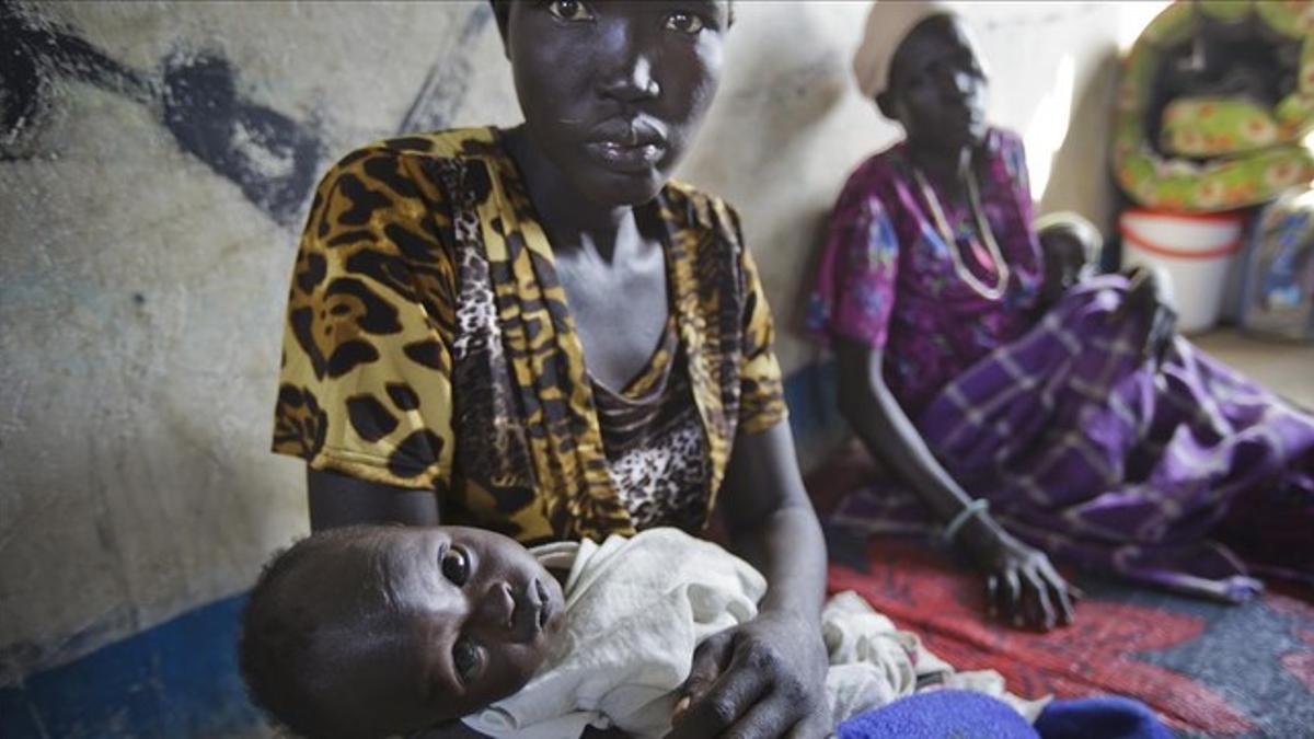 Una mujer sostiene a su hijo en brazos, víctima de la deshidratación, en un hospital de Médicos sin Fronteras en Awerial (Sudán del Sur), el pasado enero.
