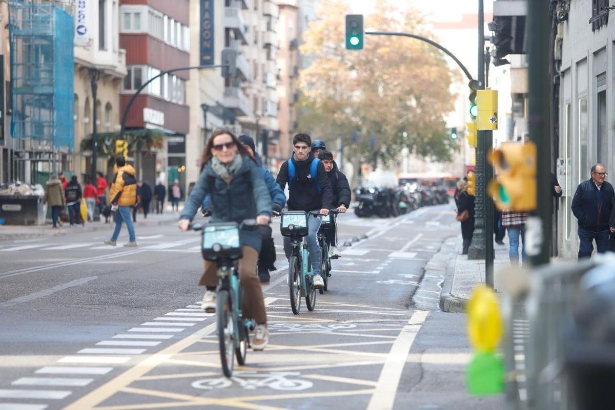 Tres usuarios del nuevo servicio de bicicletas de alquiler por el centro de la ciudad.