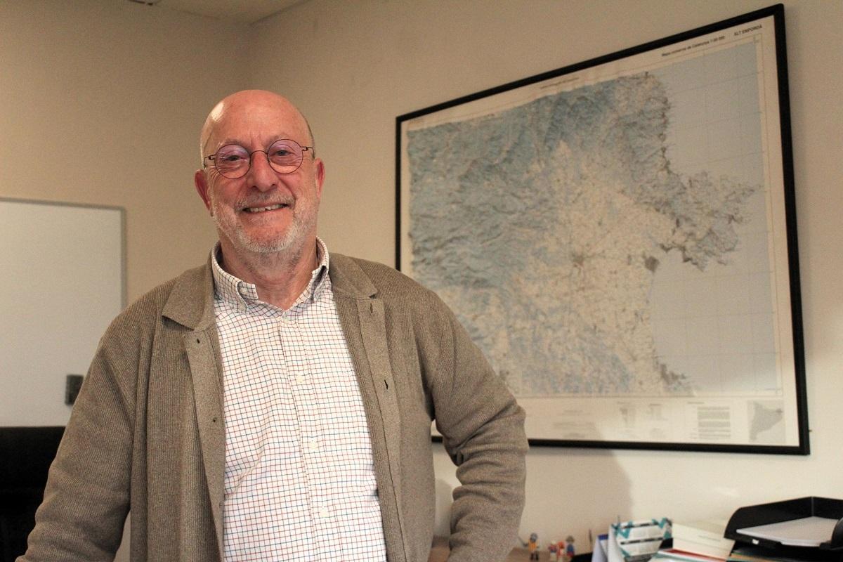 Eduard Genís en el seu despatx, presidit per un plànol en relleu de l'Alt Empordà