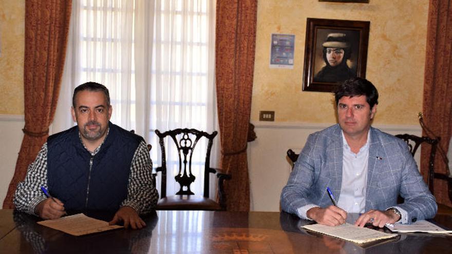 Emilio Navarro (d) firma  el convenio en presencia del secretario municipal, Argeo Manuel Tosco.
