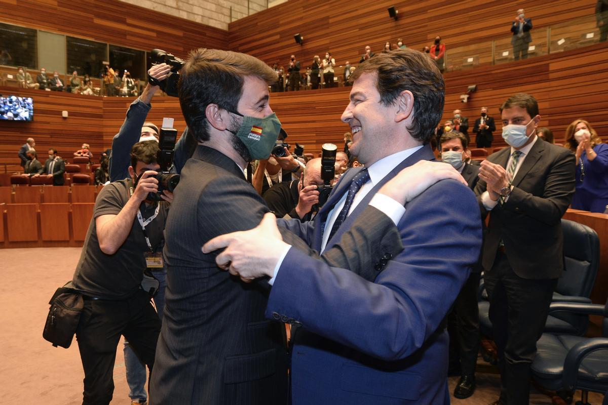 El reelegido presidente de la Junta de Castilla y León, Alfonso Fernández Mañueco, abraza al que será su vicepresidente, Juan García-Gallardo (i), de Vox, tras el debate de investidura celebrado en Valladolid el pasado 11 de abril.