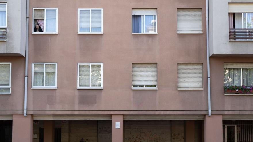 Una mujer se asoma a una ventana en el edificio de «la colmena», uno de los más habitados de Los Bloques. |