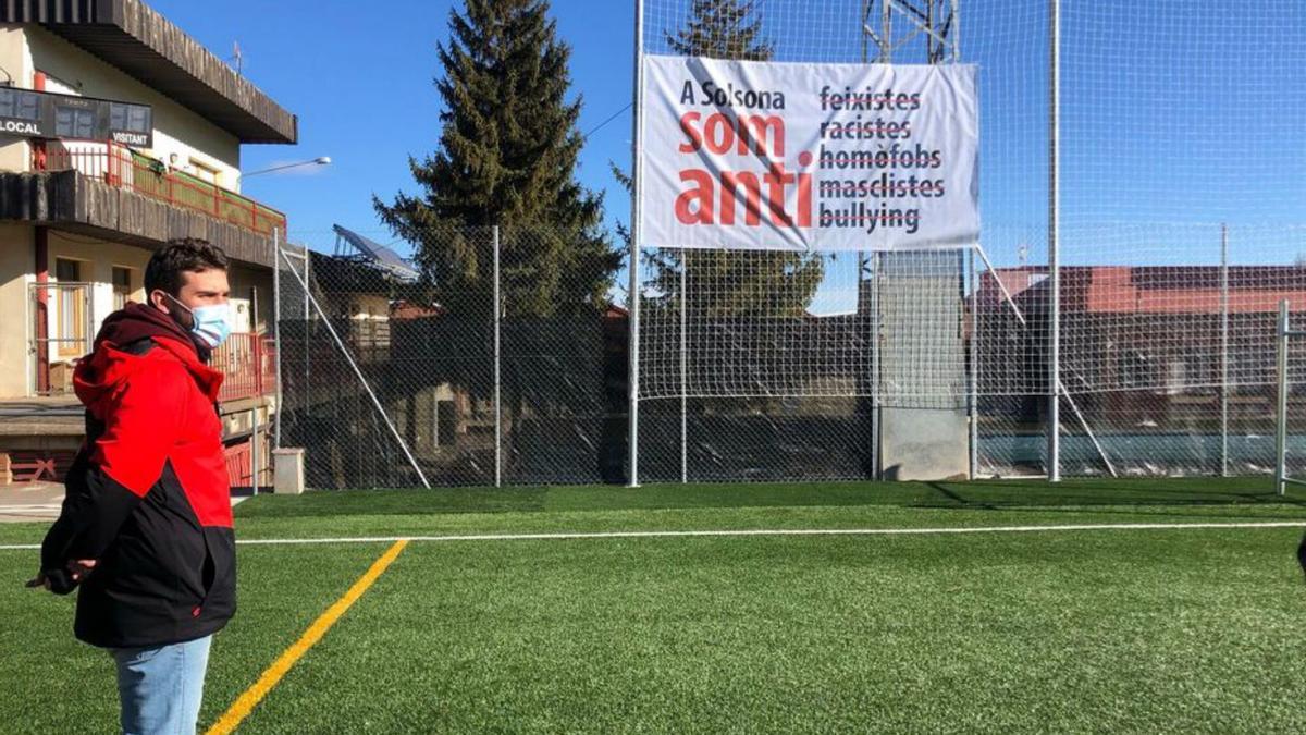 El regidor Joan Parcerisa i al fons  una pancarta al camp de futbol | AJ. SOLSONA