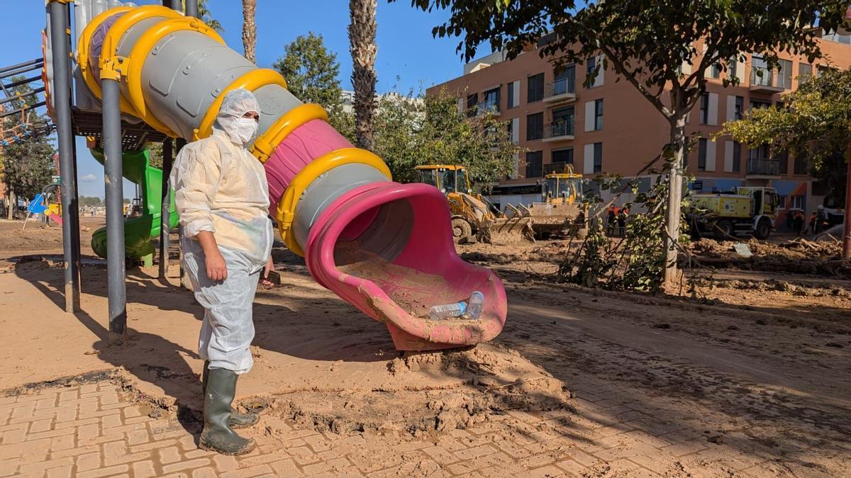 Silvia, en el parque infantil de Paiporta al que llevaba a su hija, con la maquinaria pesada de fondo.