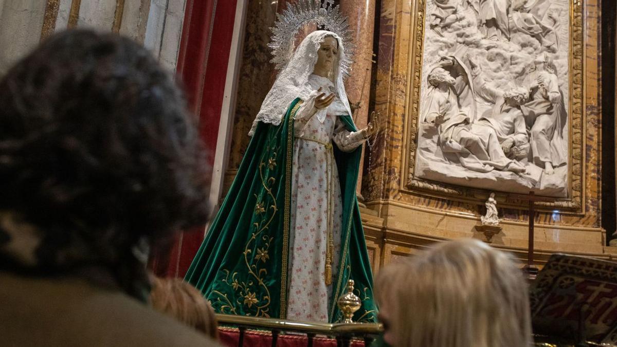 Varias personas observan la imagen situadas en el altar mayor de la Catedral