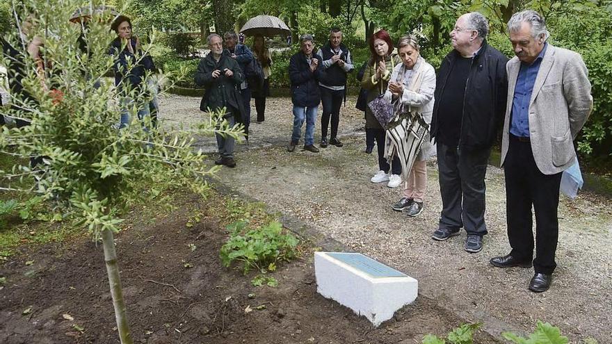 El alcalde y familiares de Ania ante la placa y el olivo que se plantó en el jardín botánico.  // Noé Parga