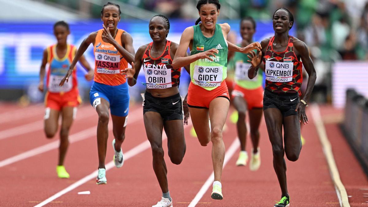 (From L) Kenya's Hellen Obiri (3rd L), Ethiopia's Letesenbet Gidey (C) and Kenya's Margaret Chelimo Kipkemboi (R) cross the finish line in the women's 10,000m final during the World Athletics Championships at Hayward Field in Eugene, Oregon on July 16, 2022. (Photo by Jewel SAMAD / AFP)